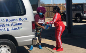 Staff handing water to a woman