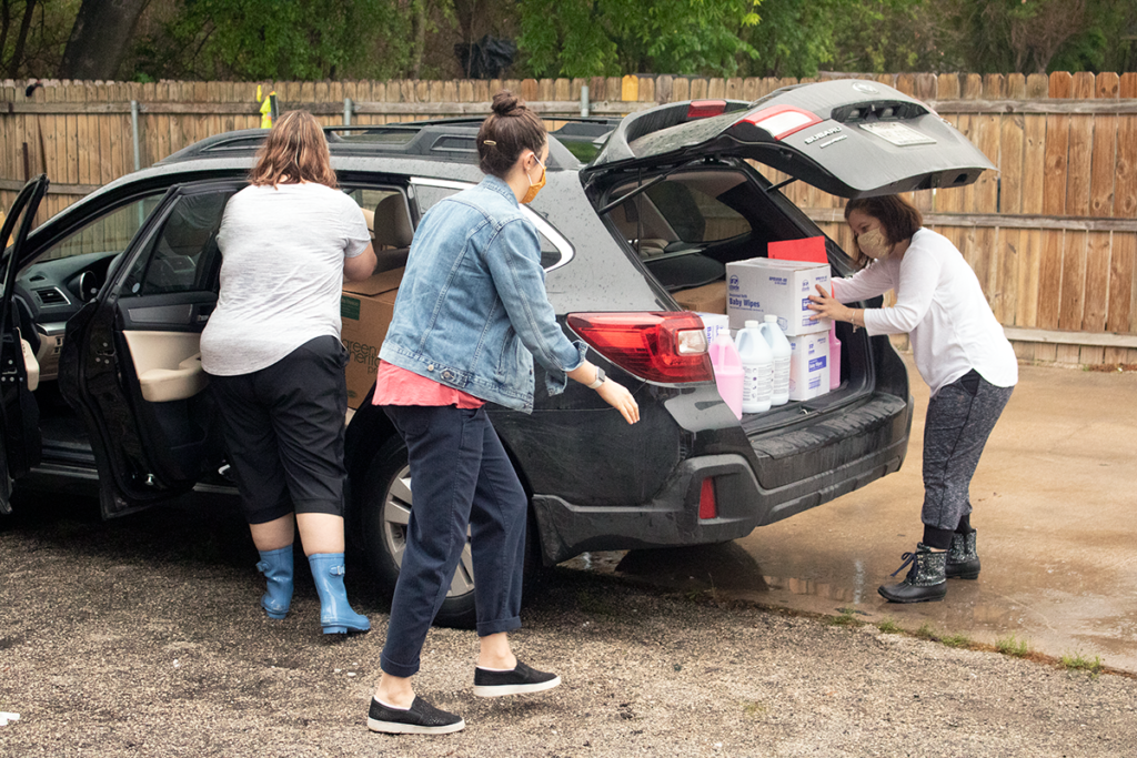 Child Care Services staff load cleaning supplies in a provider's car