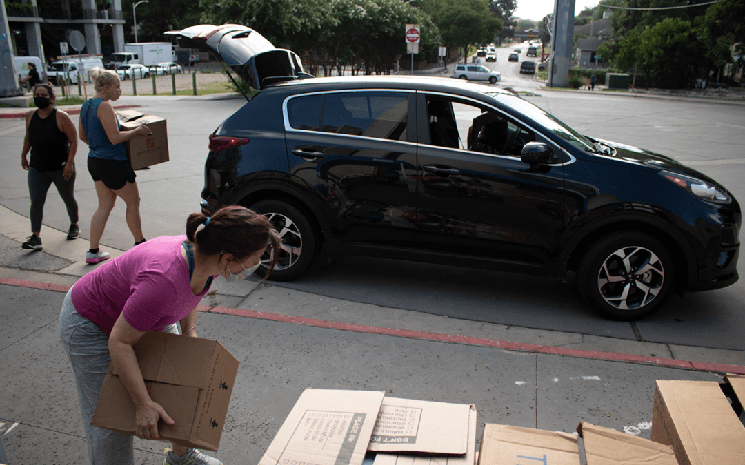 Staff loading supplies into a car